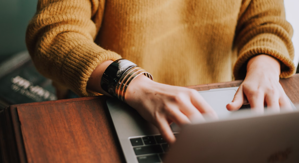 image showing woman using a laptop to support the idea to invite diverse collaborators for you livery website content